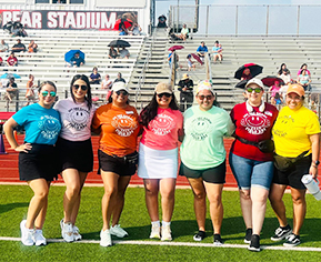 seven female teachers standing with one another in their colored field day shirts