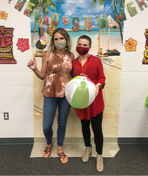 two-female-teachers-posing-with-beach-themed-props-in-front-of-backdrop